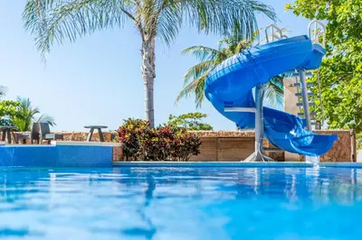 a blue water slide in a swimming pool at Crocs Resort & Casino in Jacó