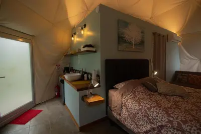 a bedroom with a tent with a bed and a sink at Pura Vista Glamping in El Castillo de La Fortuna