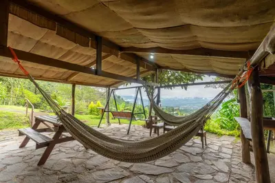 a hammock in a house with a view at Cabaña El Ciprés: Vistas increíbles y Mirador in Turrialba