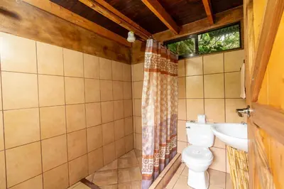 a bathroom with a toilet and a sink at Cabaña La Montaña: Vistas increíbles y Mirador in Turrialba