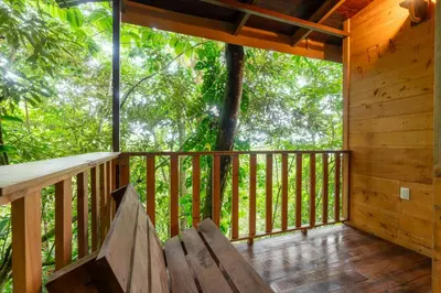a porch of a wooden cabin with a bench at Cabaña La Montaña: Vistas increíbles y Mirador in Turrialba