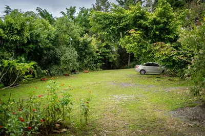 a car parked in the middle of a field at Cabaña La Montaña: Vistas increíbles y Mirador in Turrialba