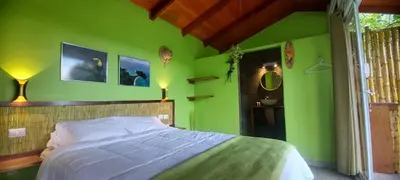 a bedroom with green walls and a bed with white sheets at Casita Maripier Colón in Morado