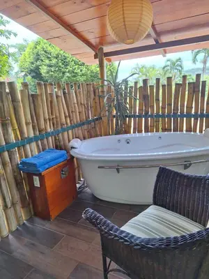 a bathroom with a tub and a chair and a wooden fence at Casita Maripier Colón in Morado