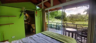 a green room with a bed and a balcony at Casita Maripier Colón in Morado