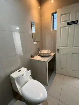 a bathroom with a white toilet and a sink at SJO Oasis Hostel in San José