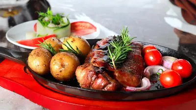 a pan of meat and vegetables on a red tray at Hotel Vista Bonita in Parrita