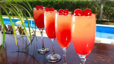 four wine glasses with cherries in them on a table at Hotel Vista Bonita in Parrita