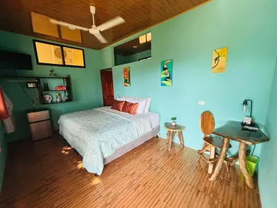 a bedroom with a bed and a wooden floor at Hotel Vista Bonita in Parrita