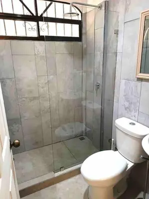 a bathroom with a white toilet and a shower at Tropical Oasis in Ojochal in Ojochal