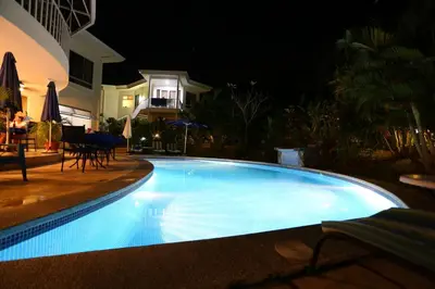 a large blue swimming pool at night at The Hideaway Hotel in Sámara