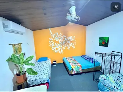 a bedroom with a bed and a couch in it at Cheap Hostel Quepos in Quepos