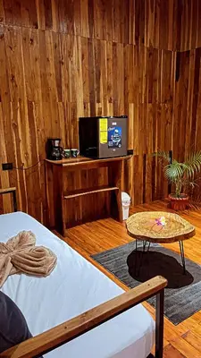 a room with a bed and a table with a tv at Río Celeste, Cacahua Lodge in Rio Celeste