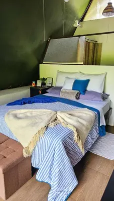 a bedroom with a bed with blue and white sheets at Flora Glamping de Abuela in Fortuna