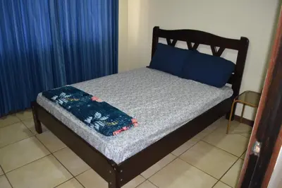 a bed with blue pillows and a blue blanket on it at SERENITY HOME H Y M in Turrialba