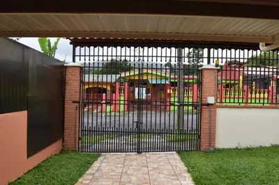 a black gate with a playground behind it at SERENITY HOME H Y M in Turrialba