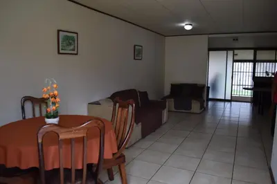 a living room with a table and a couch at SERENITY HOME H Y M in Turrialba