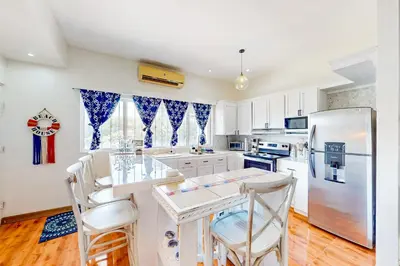 a kitchen with white cabinets and a refrigerator at La Cometa 16 in Tamarindo