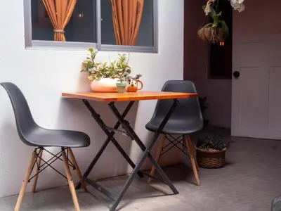 a table and two chairs sitting next to a wall at Lolas Hostal Hab Individual 2 Baño Compartido in San José