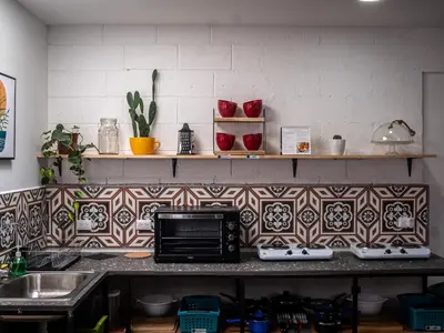 a kitchen with a counter top with a microwave at Lolas Hostal Hab. doble (baño privado) in San José