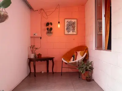 a corner of a room with a bench and a table at Lolas Hostal Hab. doble (baño privado) in San José