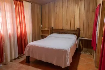 a small bedroom with a bed and wooden walls at Cabaña Campo Verde in Marsella