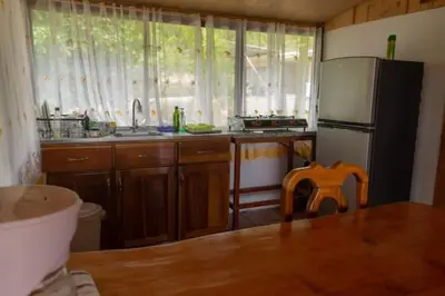 a kitchen with a refrigerator and a sink and a table at Cabaña Campo Verde in Marsella