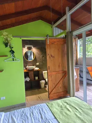 a bedroom with a wooden door and a green wall at Casita Maripier in Morado