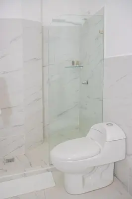 a white bathroom with a toilet and a shower at The Stay San Jose in San José