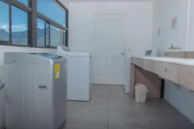a bathroom with a sink and a washing machine at The Stay San Jose in San José