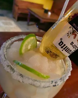 a drink with a bottle and a lime on top at Hotel Aurora Inn, Nuevo Arenal in Nuevo Arenal
