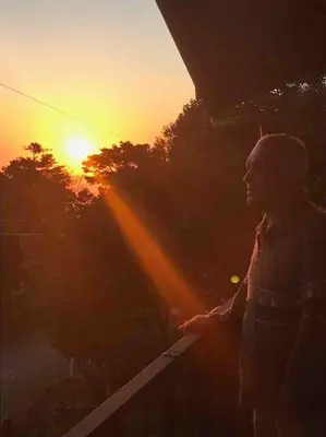 a man is standing in front of the sunset at Alma Verde 2 in Monteverde Costa Rica