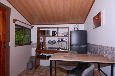 a kitchen with a table and a refrigerator at Alma Verde 2 in Monteverde Costa Rica