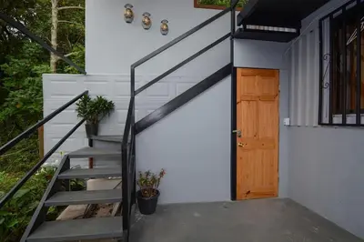a staircase leading up to a house with a wooden door at Alma Verde 2 in Monteverde Costa Rica