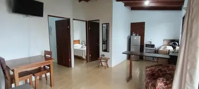 a living room with a table and a bedroom at Casa Pitahaya in Monteverde Costa Rica