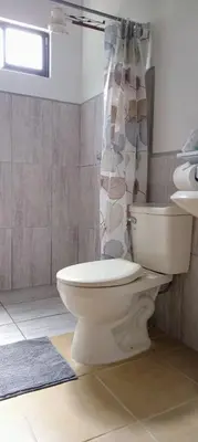 a bathroom with a toilet and a shower curtain at Casa Pitahaya in Monteverde Costa Rica
