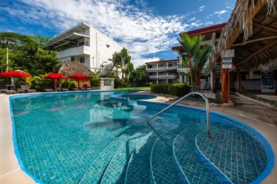 a swimming pool at a resort with umbrellas at Jaco Laguna Resort & Beach Club in Jacó