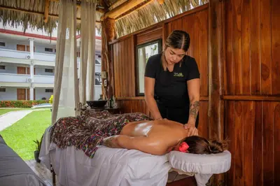 a woman giving a man a massage on a bed at Jaco Laguna Resort & Beach Club in Jacó