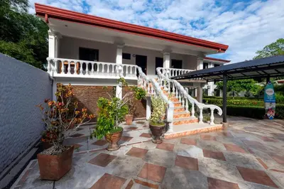 a house with a staircase and potted plants at Jaco Laguna Resort & Beach Club in Jacó