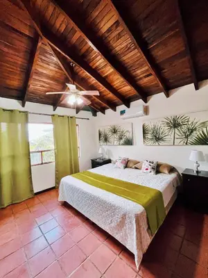 a bedroom with a bed and a ceiling fan at Siwõ Art Guesthouse in Ocotal