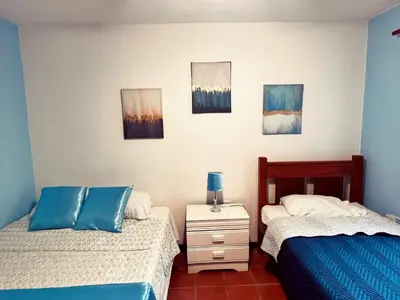 a bedroom with two twin beds and paintings on the wall at Siwõ Art Guesthouse in Ocotal