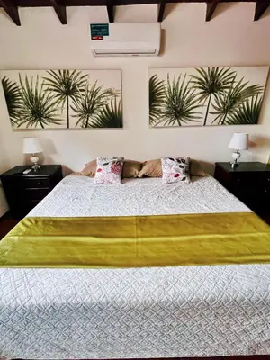 a bedroom with a large bed with plants on the wall at Siwõ Art Guesthouse in Ocotal