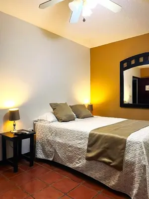 a bedroom with a bed and a mirror on the wall at Siwõ Art Guesthouse in Ocotal