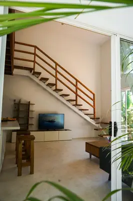 a living room with a staircase and a tv at Villa SOL in Santa Teresa Beach