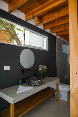 a bathroom with a sink and a mirror and a toilet at Villa SOL in Santa Teresa Beach