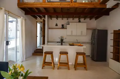 a kitchen with a counter and stools in a room at Villa SOL in Santa Teresa Beach