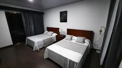 a hotel room with two beds with white sheets at Arenal Monara in Fortuna