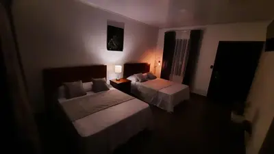 a dark room with two beds and a window at Arenal Monara in Fortuna