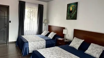 a hotel room with two beds and a window at Arenal Monara in Fortuna