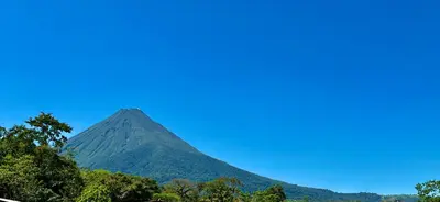 a mountain in the distance with trees in the foreground at Arenal Monara in Fortuna